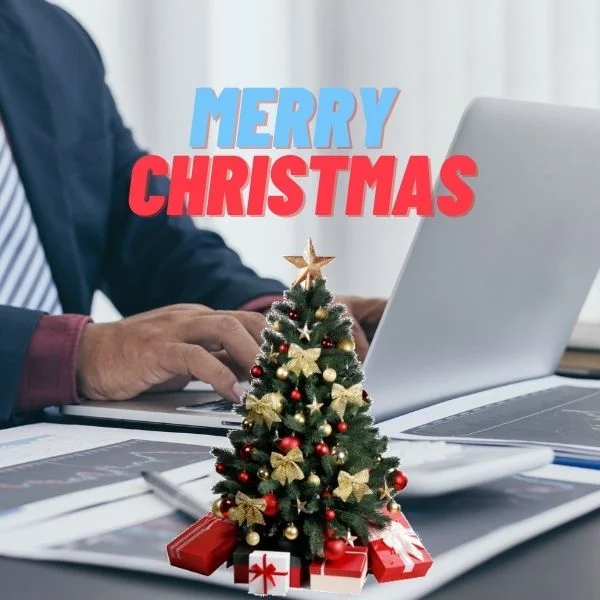a men working on his desk with christmas tree giving Corporate Christmas messages